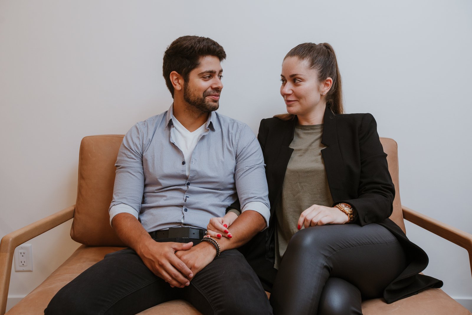 Couple sitting close together holding hands, representing couples therapy in Vancouver